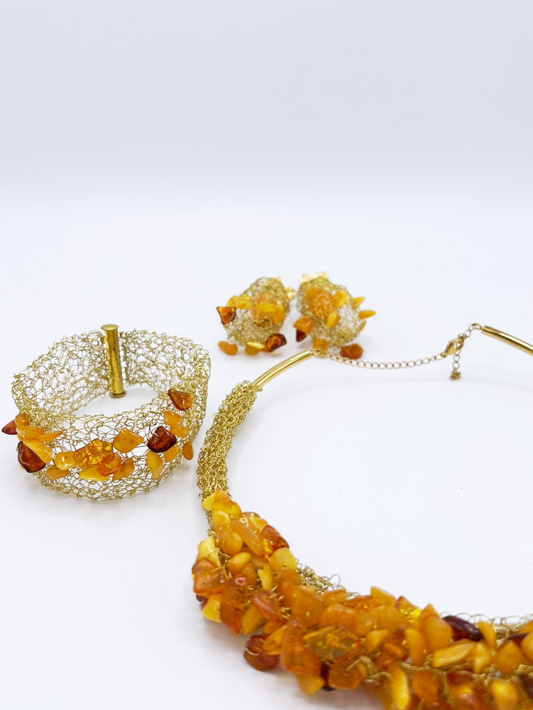 Collar, pendientes y brazalete en acero dorado y ámbar