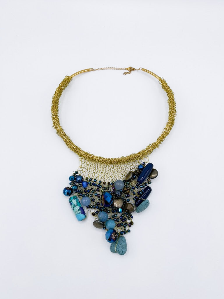 Collar tejido en dorado con piedras en gama de azules