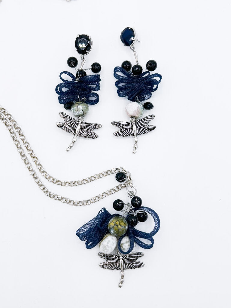 Collar en cadena plateada con libélula de acero y serpentina entrelazada con piedras negras, y pendientes a juego