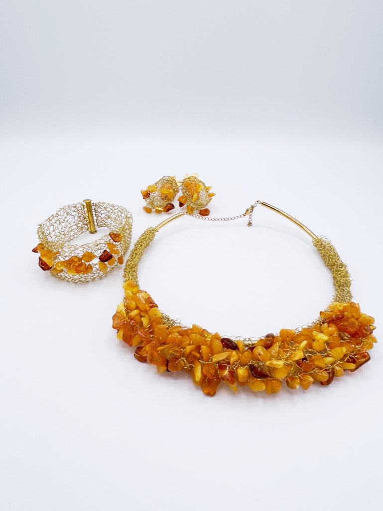 Collar, pendientes y brazalete en acero dorado y ámbar