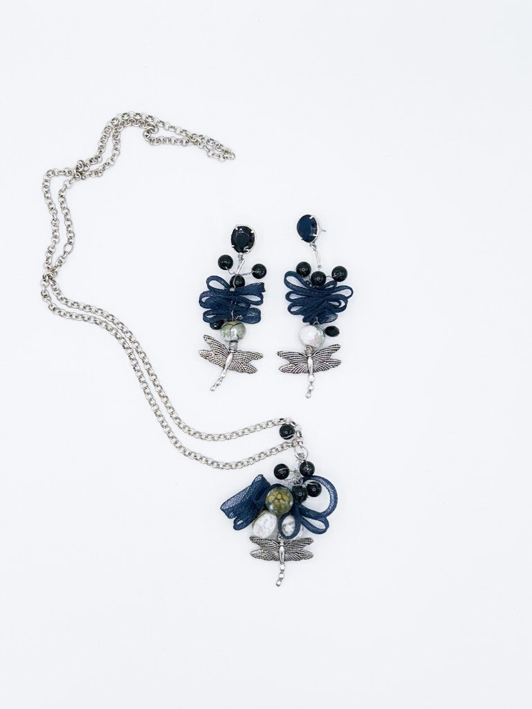 Collar en cadena plateada con libélula de acero y serpentina entrelazada con piedras negras, y pendientes a juego