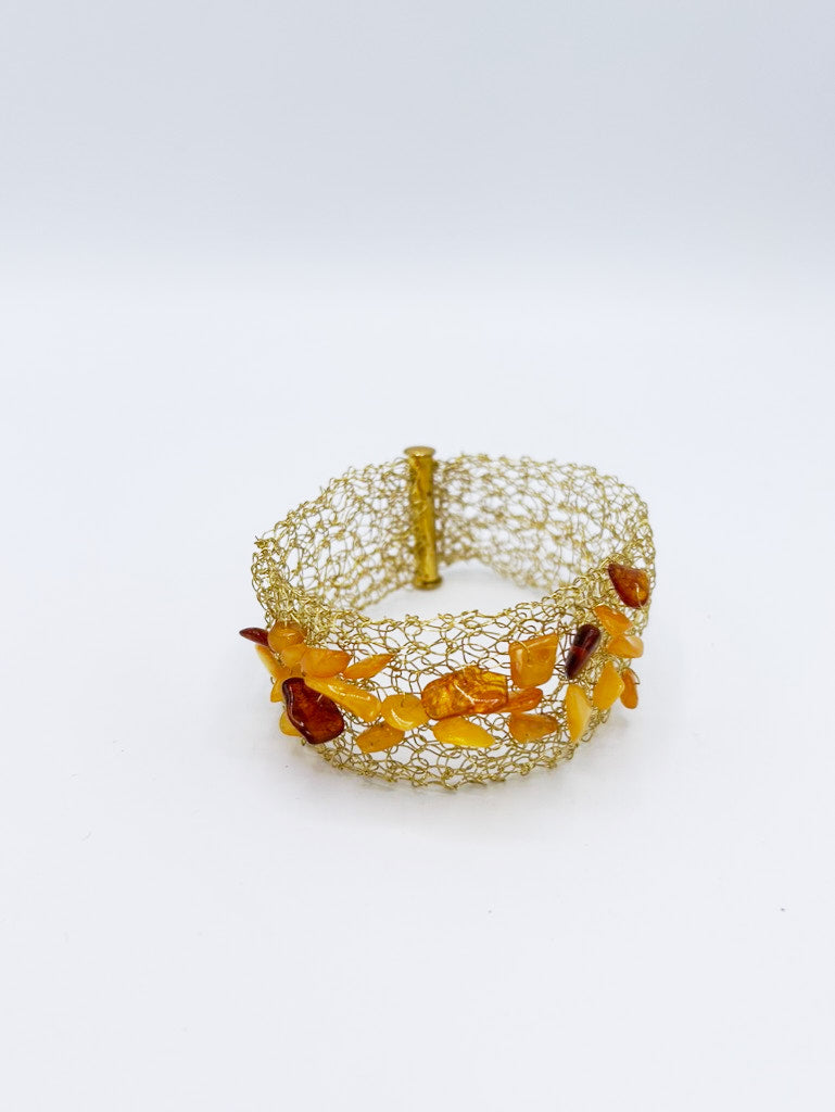 Collar, pendientes y brazalete en acero dorado y ámbar