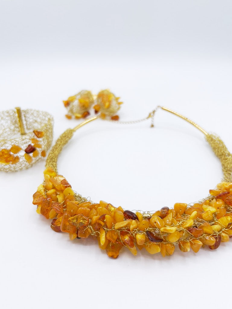 Collar, pendientes y brazalete en acero dorado y ámbar
