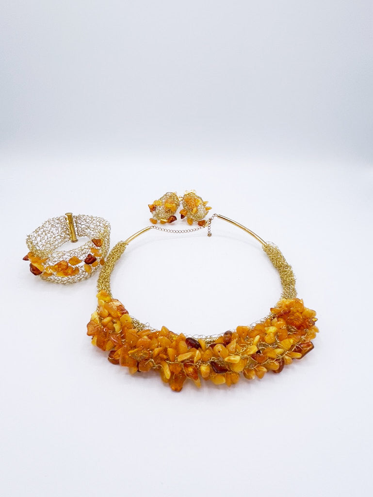 Collar, pendientes y brazalete en acero dorado y ámbar