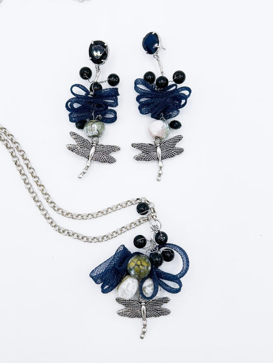 Collar en cadena plateada con libélula de acero y serpentina entrelazada con piedras negras, y pendientes a juego