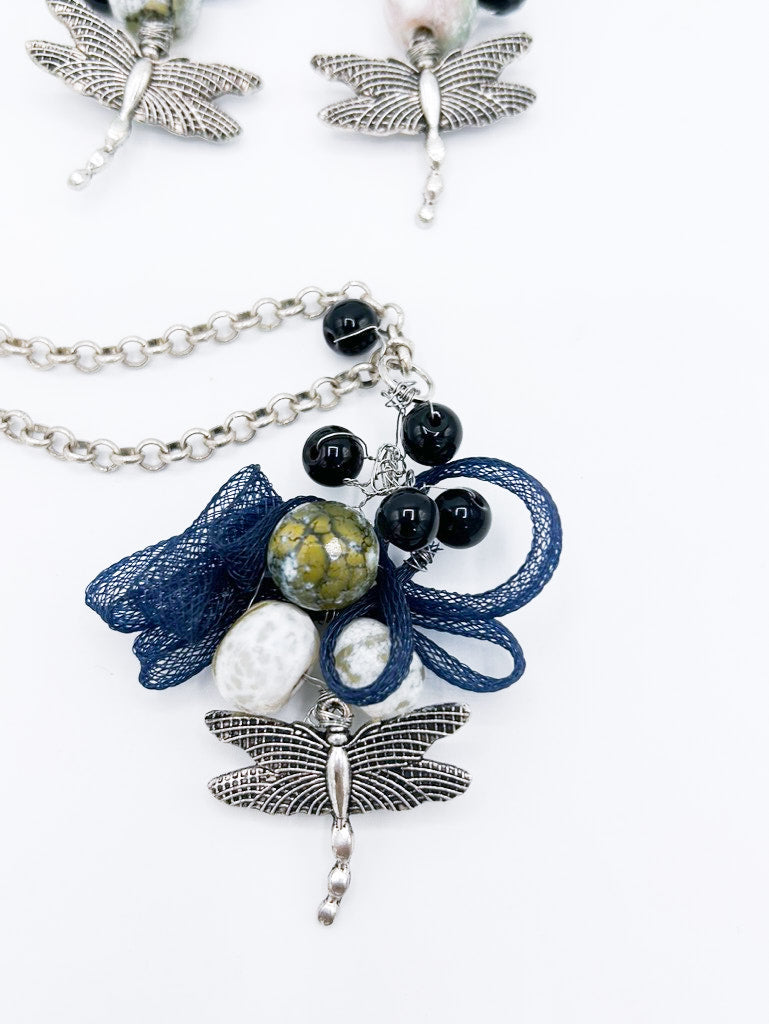 Collar en cadena plateada con libélula de acero y serpentina entrelazada con piedras negras, y pendientes a juego