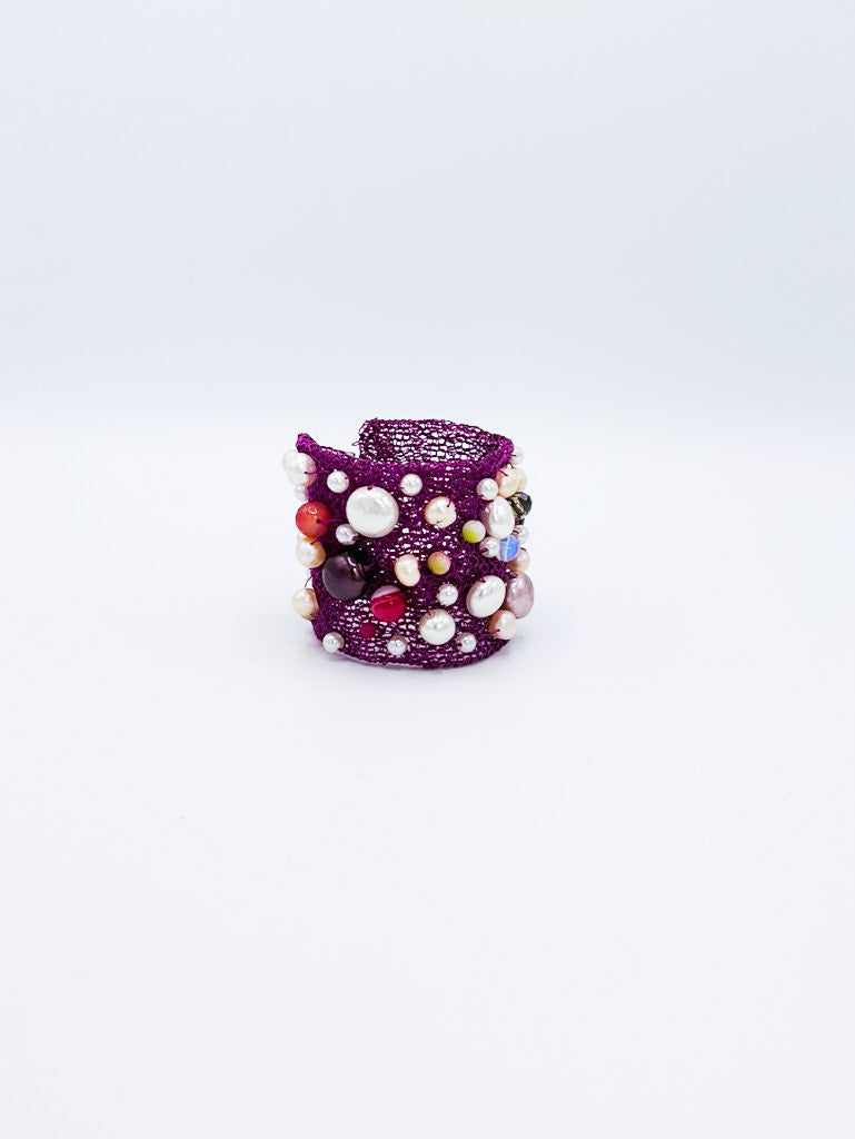 Brazalete en acero color magenta con perlas multicolores